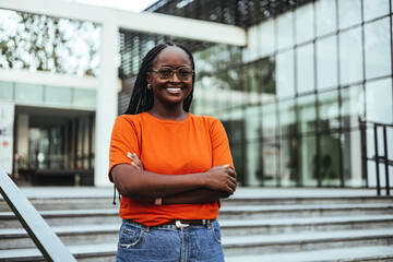 Confident Young Woman Smiling Outside Modern Office Building