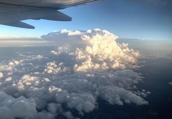 Fototapeta premium Stunning View of Fluffy White Clouds from Airplane Window During Daytime Flight Above Scenic Sky Landscape