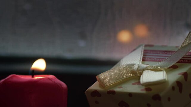 Holy Christmas New Year Eve Decoration and Gift Boxes on Candle Light Near the Window Glass in Rainy Day
