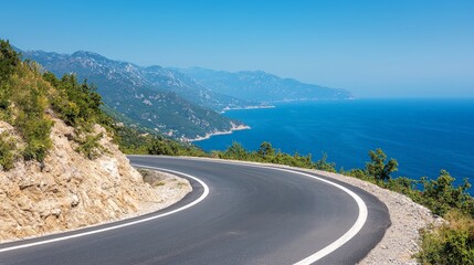 Scenic coastal highway winding along a mountainous coastline, overlooking the tranquil blue sea under a clear sky.