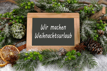 Tafel mit der Beschriftung wir machen Weihnachtsurlaub mit weihnachtlicher Dekoration