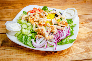 Salad in a white plate with meat and vegetables