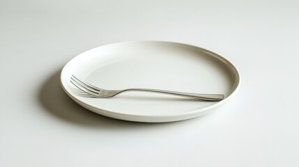 Minimalist white plate with fork on plain background.
