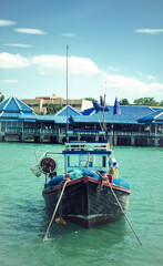 A blue boat is parked against a background of blue houses