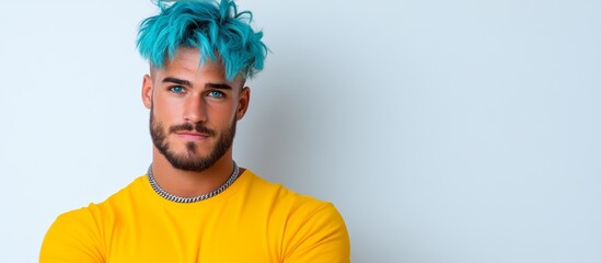 Fototapeta premium Man with blue hair and a yellow shirt. He is looking at the camera. The image has a bright and cheerful mood