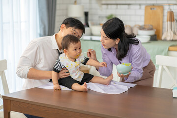 Fototapeta premium Asian baby and families who have to work while raising children at home