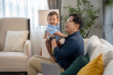 Obraz premium Asian baby and families who have to work while raising children at home