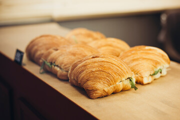 Freshly baked croissants with salty fillings in the bakery window.