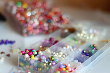 Hand figurine, colorful friendship bracelets, necklaces, various beads and DIY supplies on the...