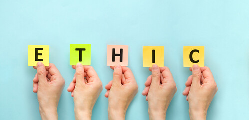 The word ETHIC is written on multicolored sticker on a light blue background