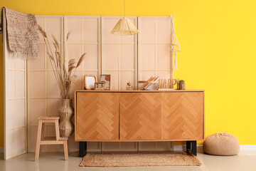 Interior of living room with wooden folding screen and commode