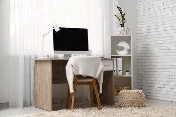 Modern home office with computer near window in room