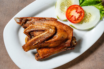 Bebek Goreng, Traditional Fried Duck. Popular Menu came from Madura, East Java. served with sambal, cucumber, tomato and lettuce.