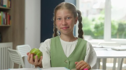 Happy kid Caucasian child schoolgirl teen smiling girl pupil student daughter learning studying in school class throwing apple lunch fruit snack education break lesson healthy nutrition food health