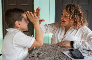 Autistic Boy Sharing a High-Five with His Mother at Home
