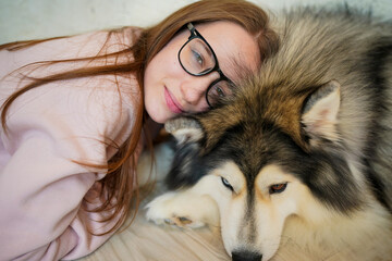 A girl with a husky in a snowy winter setting