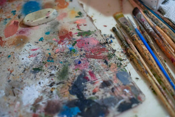 Obraz premium Paints and brushes are laid out on the table - this is the artist's workplace.