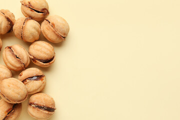 Many sweet walnut shaped cookies with boiled condensed milk on yellow background