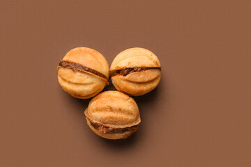 Sweet walnut shaped cookies with boiled condensed milk on brown background