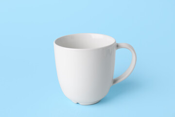 White empty ceramic mug on blue background
