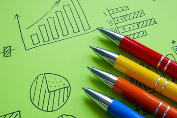 Pens lying on marketing or business graphs. Strategic planning concept.
