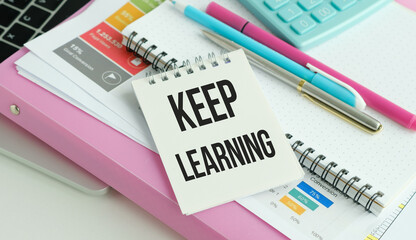 KEEP LEARNING text written on notebook paper with calculator on chart background
