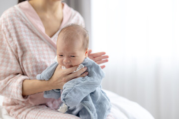 Mother assisting baby with burping after feeding