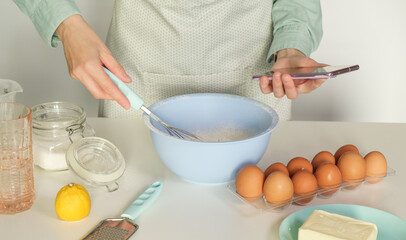 Person baking using mobile app for finding the recipe