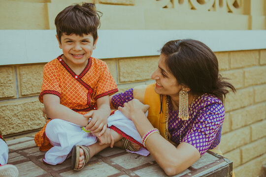 A mother and her son pose on a wooden safe in a palace wearing traditional Indian Rajasthani and Gujarati ethnic wear for a Hindu Wedding at Khirasara Palace in Rajkot