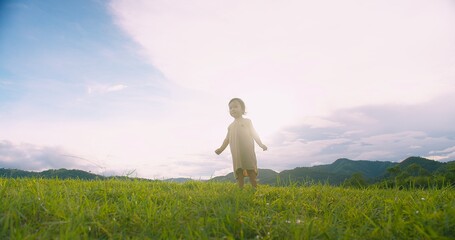 Fototapeta premium A young adorable child girl stands in a grassy field Sunlit Meadow gazing at the sky, Capturing a Sense of Wonder and Adventure in a Serene Natural