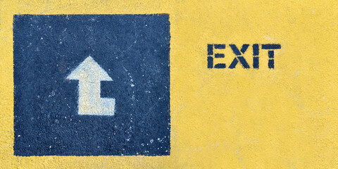 exit sign with arrow direction way on grunge concrete floor with copy space