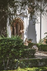 Serene garden scene with lush greenery and an archway casting soft shadows