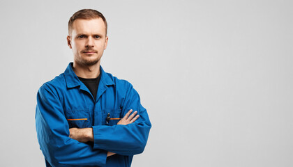 portrait of a mechanic man standing and folded hands isolated on white background