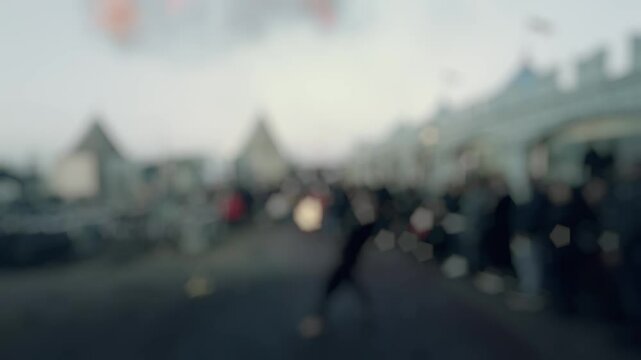 Fire performer creates mesmerizing display at carnival. Artistic heavy blur bokeh transforms fairground scene into dreamy spectacle filled with mystery. Slow motion.
