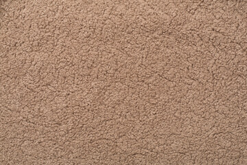 Brown cuddle teddy bear fabric as background, top view