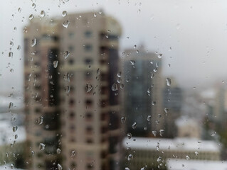 A view of a city through a window with raindrops on it