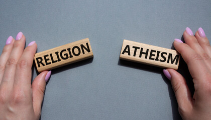 Religion or Atheism symbol. Concept word Religion or Atheism on wooden blocks. Businessman hand. Beautiful grey background. Business and Religion or Atheism concept. Copy space