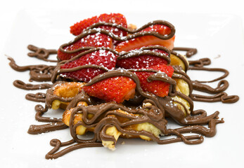Waffles con chocolate y fresas en un plato blanco en primer plano
