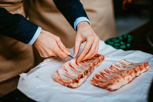 chef prepares pork ribs for cooking with precision and care
