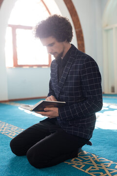 man holding and reading Quran