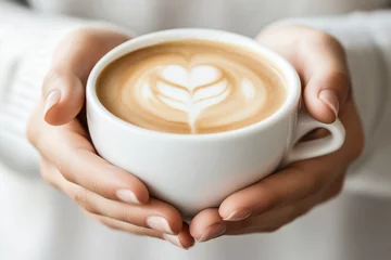 Gordijnen Two hands hold a cup of coffee in which the foam forms a spike shape. The image conveys warmth and tranquility when drinking coffee. AI © Ricardo MzF .com 