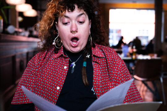 Young woman astonished about the menu 