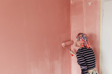 Woman painting wall at home