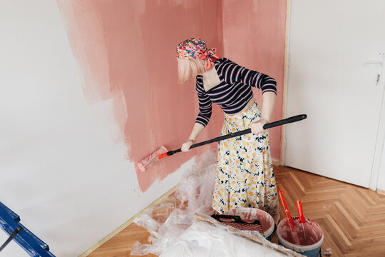 Woman painting wall at home, first move