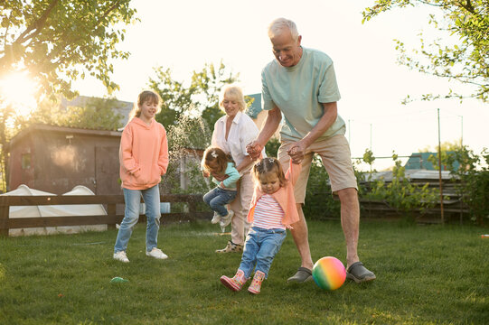 Grandparents playing their grandchildren on a backyard