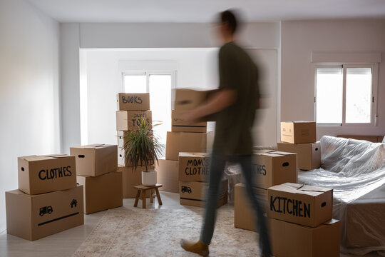 Anonymous man bringing boxes with belongings to new home