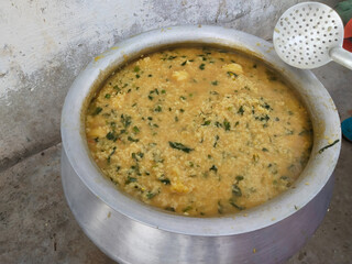 making khichdi in very heavy and huge pot for many peoples in village family. Dal Khichdi, a wholesome Indian comfort meal. creamy lentil and rice dish, often paired with spices and ghee