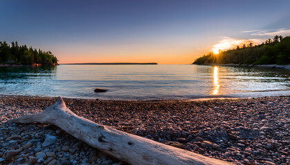 Serenity of Lake Superior at sunset with driftwood on a pebbled beach inviting wanderlust