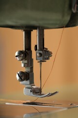 Vintage sewing machine with thread on blurred background, macro view