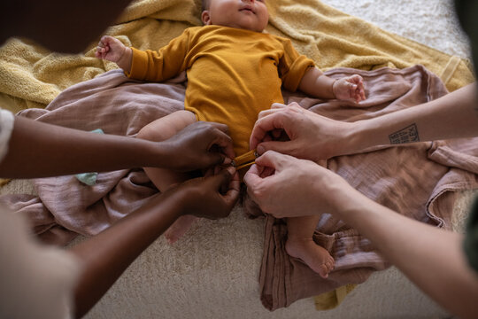Parents dressing newborn